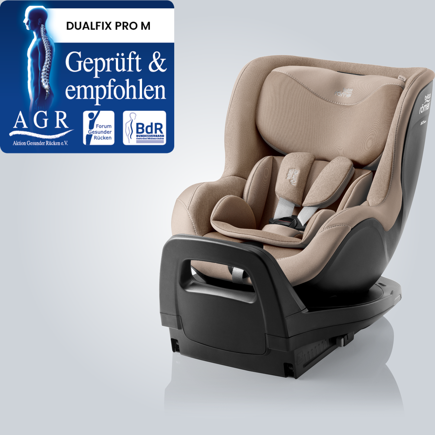 DUALFIX PRO M in Teak, ein um 360&deg; drehbarer Kleinkindautositz mit verstellbarer Kopfst&uuml;tze und Gurtsystem, in schr&auml;ger Vorderansicht dargestellt mit dem &bdquo;Gepr&uuml;ft & Empfohlen&ldquo;-Siegel der Aktion Gesunder R&uuml;cken e.V.