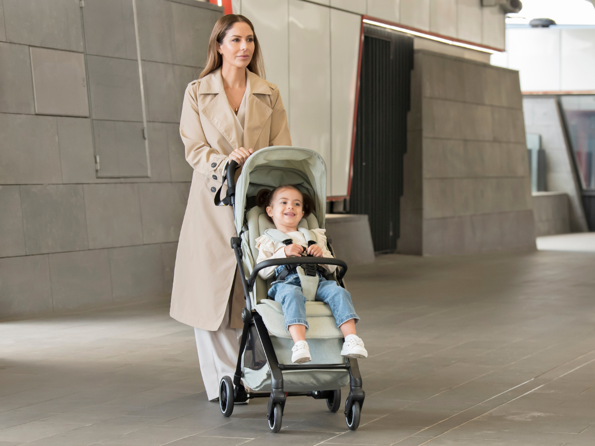 Elternteil schiebt den kompakten Britax Römer FLYLITE Reisebuggy mit einem Kleinkind
